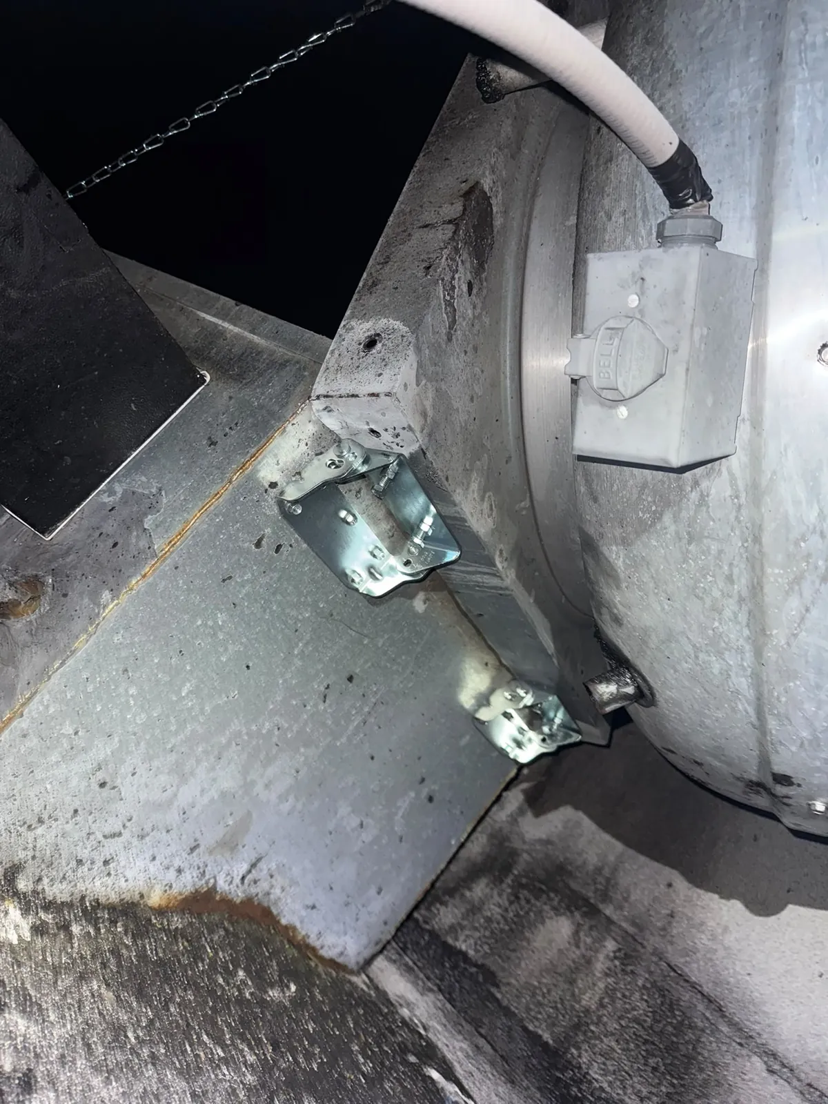 Close-up of a hinge installed on commercial rooftop exhaust equipment
