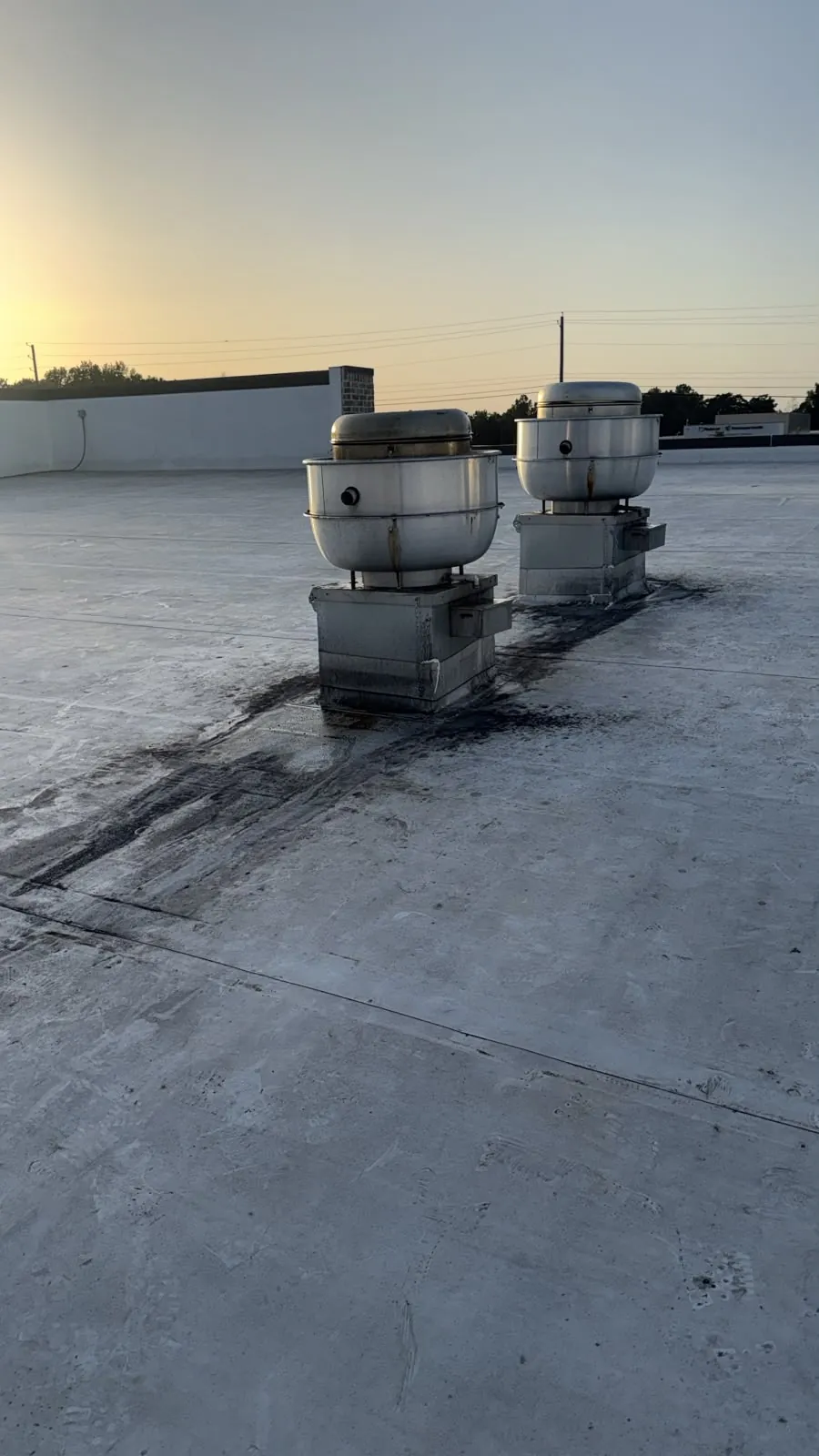 Grease buildup surrounding two rooftop exhaust fans before cleaning